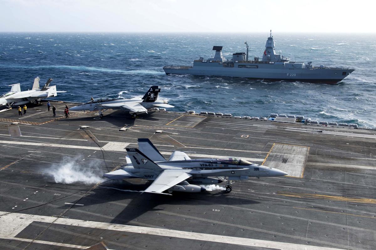 F-18C_of_VFA-83_lands_on_USS_Eisenhower_(CVN-69)_with_frigate_Hamburg_(F220)_in_the_background_2013